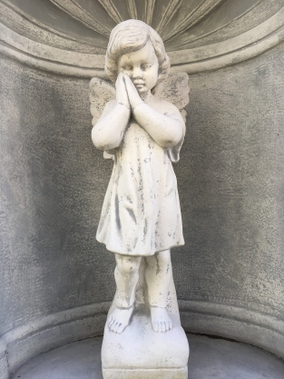 Mooi staand engelbeeld vol steen in bidkapel vol steen.